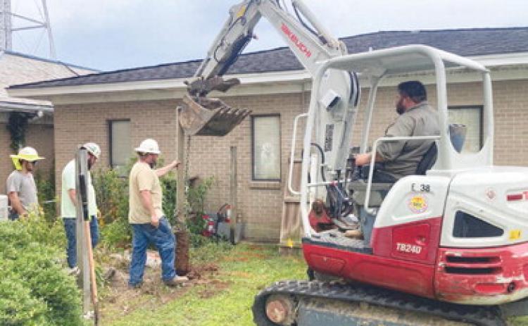POWER RESTORATION - A crew from Southern Electric Corporation removed a fence post in order to get to beginning digging up three underground power lines that feed electricity the Cleveland County Courthouse and the Cleveland County Sheriff's Department.